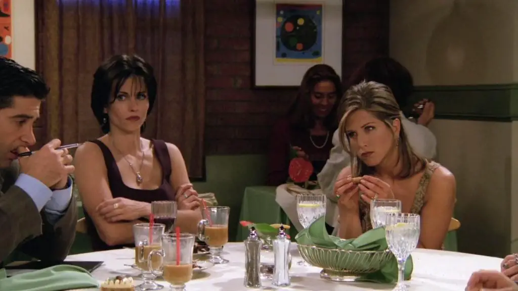 Ross (David Schwimmer) ponders how much everybody owes after a dinner while Monica (Courteney Cox) and Rachel (Jennifer Aniston) look on.
